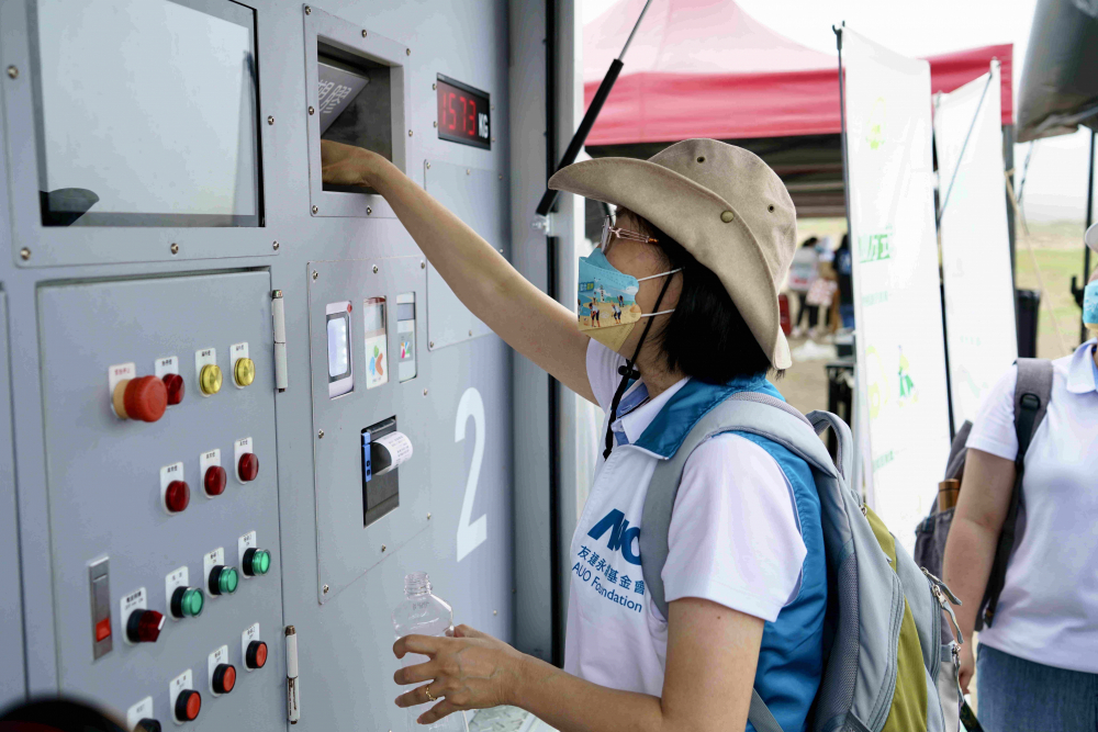 志工們將拾起的寶特瓶投入「好歸塑專車」，讓廢棄塑料空瓶可以直接粉碎、縮小體積，未來(lái)將可再製成購(gòu)物袋、寶特衣、悠遊卡等生活用品
